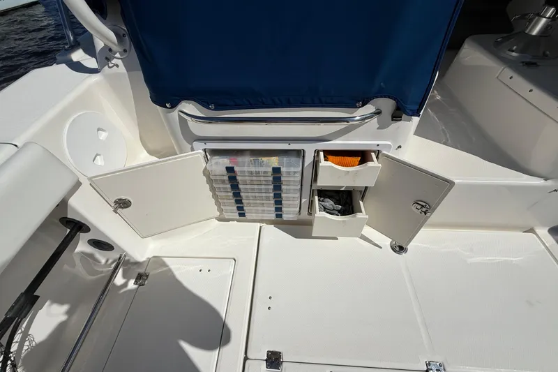 Slide: The Image of 2015 Robalo R305 Walkaround boat storage compartments with open drawers and tackle boxes. - 31