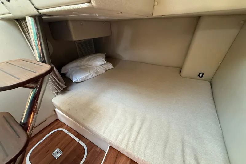 Slide: The Image of 2015 Robalo R305 Walkaround cabin interior with bed and wooden steps. - 32