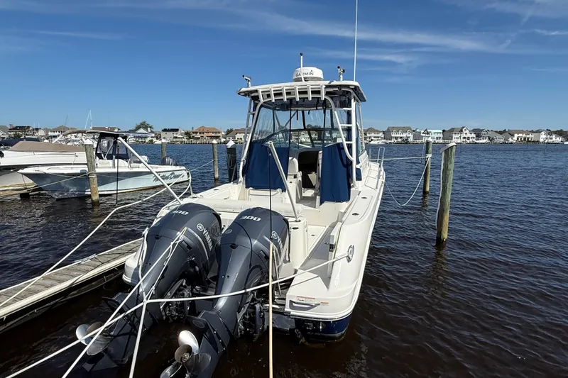 Slide: The Image of 2015 Robalo R305 Walkaround boat docked with twin Yamaha engines. - 4