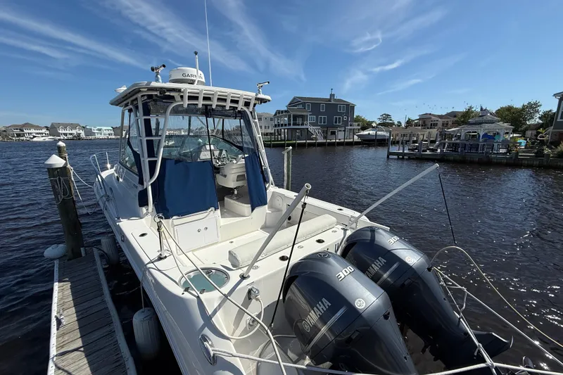 Slide: The Image of 2015 Robalo R305 Walkaround boat docked with twin Yamaha engines, waterfront view. - 6