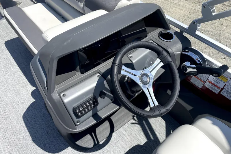 Slide: The Image of 2026 Sun Tracker Fishin' Barge 22 DLX steering console with modern controls and seating. - 11