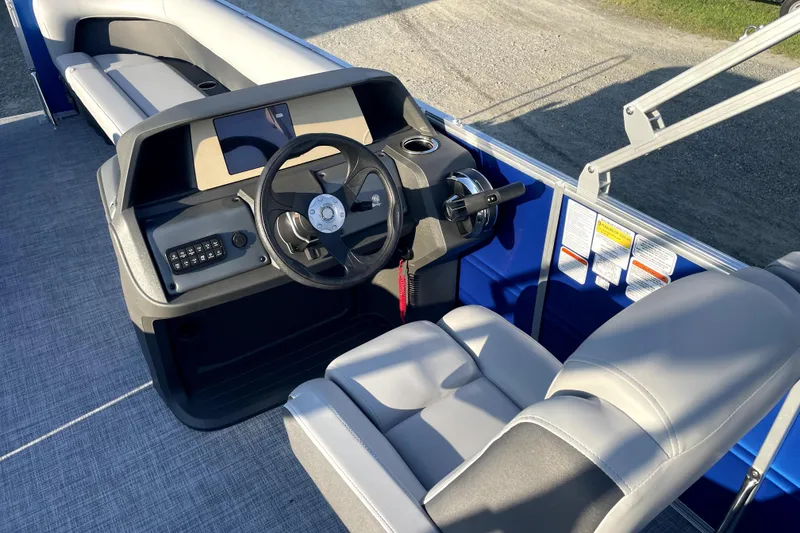 Slide: The Image of 2026 Sun Tracker Fishin' Barge 22 DLX boat interior with steering console and seating. - 13