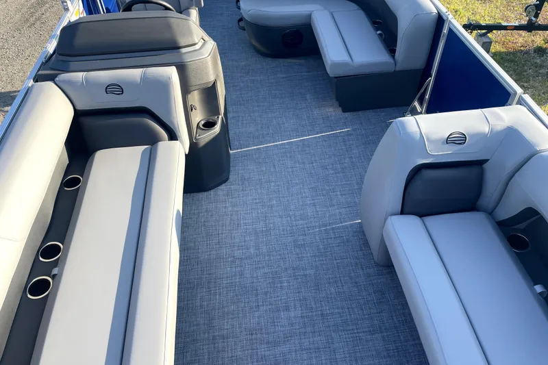 Slide: The Image of 2026 Sun Tracker Fishin' Barge 22 DLX interior with gray seating and cup holders. - 15