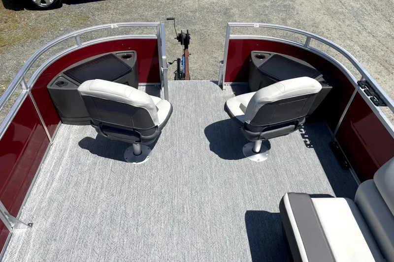 Slide: The Image of 2026 Sun Tracker Fishin' Barge 22 DLX interior with two swivel seats and red paneling. - 17