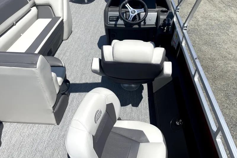 Slide: The Image of 2026 Sun Tracker Fishin' Barge 22 DLX interior with steering wheel and seating. - 18