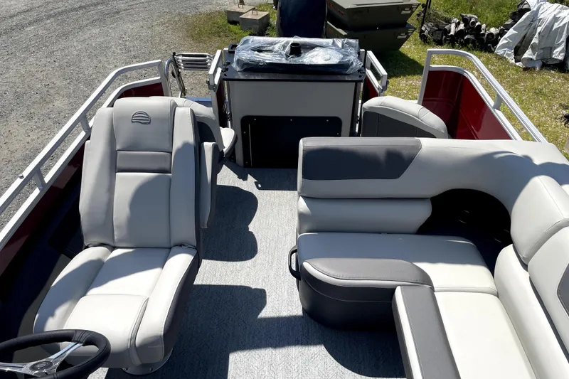 Slide: The Image of 2026 Sun Tracker Fishin' Barge 22 DLX interior with plush seating and steering console. - 22