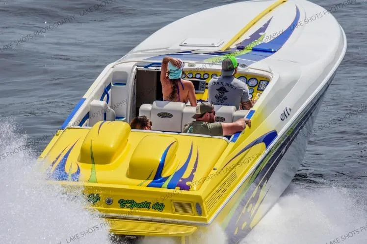 The Image of 1999 Outerlimits 37 Stiletto speedboat with vibrant yellow and blue design on the water. - 1