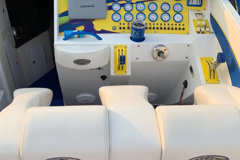 Slide: The Image of 1999 Outerlimits 37 Stiletto boat cockpit with gauges, Garmin device, and white seating. - 11