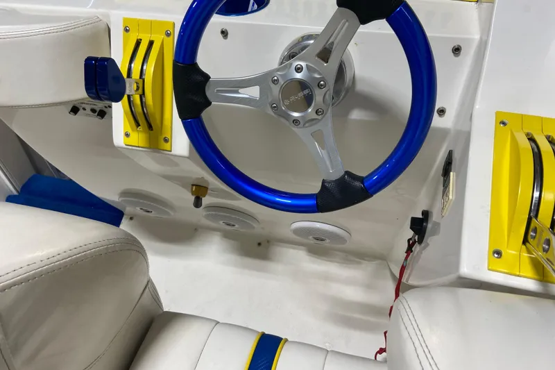 Slide: The Image of 1999 Outerlimits 37 Stiletto cockpit with blue steering wheel and yellow throttle controls. - 12