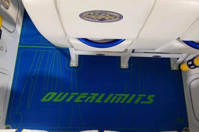 Slide: The Image of 1999 Outerlimits 37 Stiletto boat interior with branded blue flooring and white seating. - 13