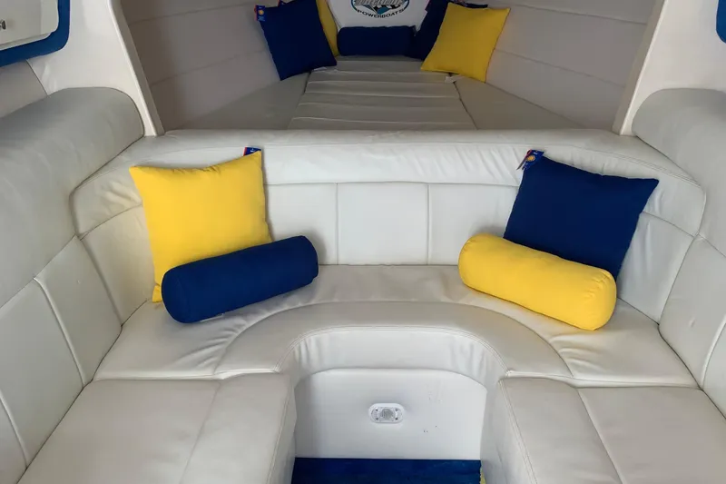 Slide: The Image of Interior of a 1999 Outerlimits 37 Stiletto with white seating and colorful cushions. - 16