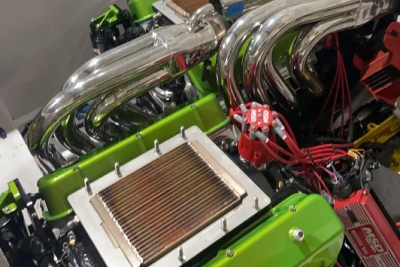 Slide: The Image of Engine of a 1999 Outerlimits 37 Stiletto with chrome exhaust and vibrant green accents. - 20