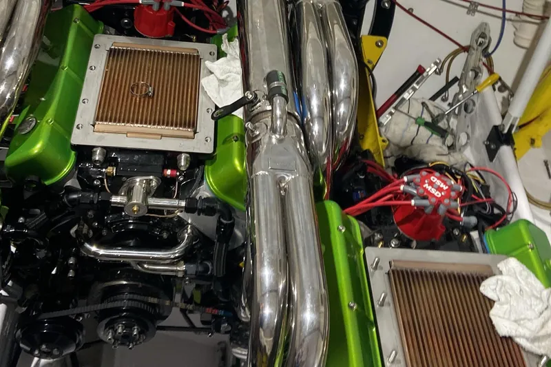 Slide: The Image of Engine components of a 1999 Outerlimits 37 Stiletto boat, featuring green accents and chrome details. - 21