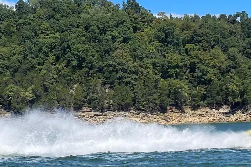 Slide: The Image of Wake from a 1999 Outerlimits 37 Stiletto boat on a scenic lake. - 4