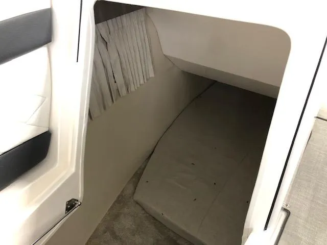 Slide: The Image of 2020 Regal 3300 Bowrider cabin interior with bed and curtain. - 13