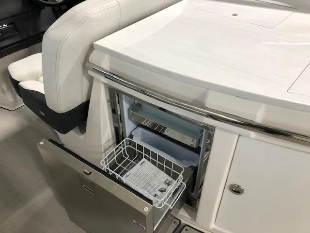 Slide: The Image of 2020 Regal 3300 Bowrider interior with open mini fridge and storage compartment. - 14