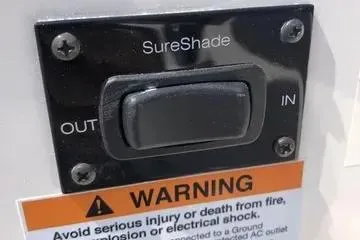 Slide: The Image of SureShade control switch on 2020 Regal 3300 Bowrider with safety warning label. - 22