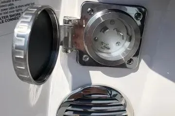 Slide: The Image of 2020 Regal 3300 Bowrider shore power inlet with protective cover open. - 24