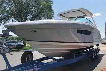 Slide: The Image of 2020 Regal 3300 Bowrider boat on trailer, parked outdoors under clear sky. - 3