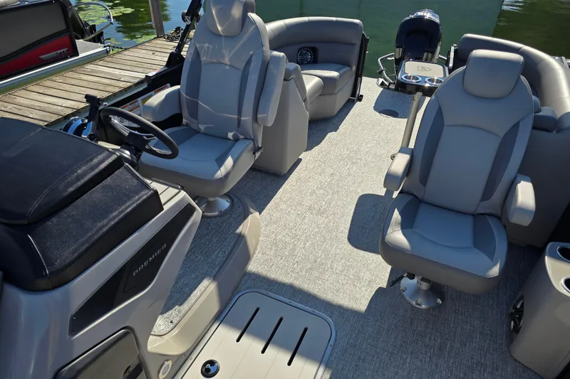 Slide: The Image of 2025 Premier 210 Sunsation RF pontoon boat interior with plush seating and modern helm. - 16