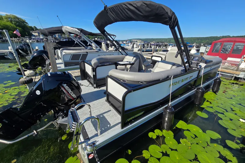 Slide: The Image of 2025 Premier 210 Sunsation RF pontoon boat docked, surrounded by lily pads. - 3
