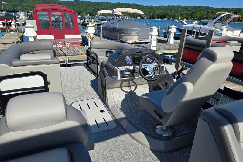 Slide: The Image of 2025 Premier 210 Sunsation RF pontoon boat interior at a marina dock. - 9
