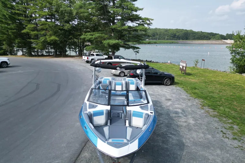 Slide: The Image of 2024 Malibu Wakesetter 23 LSV boat parked near a scenic lake. - 10