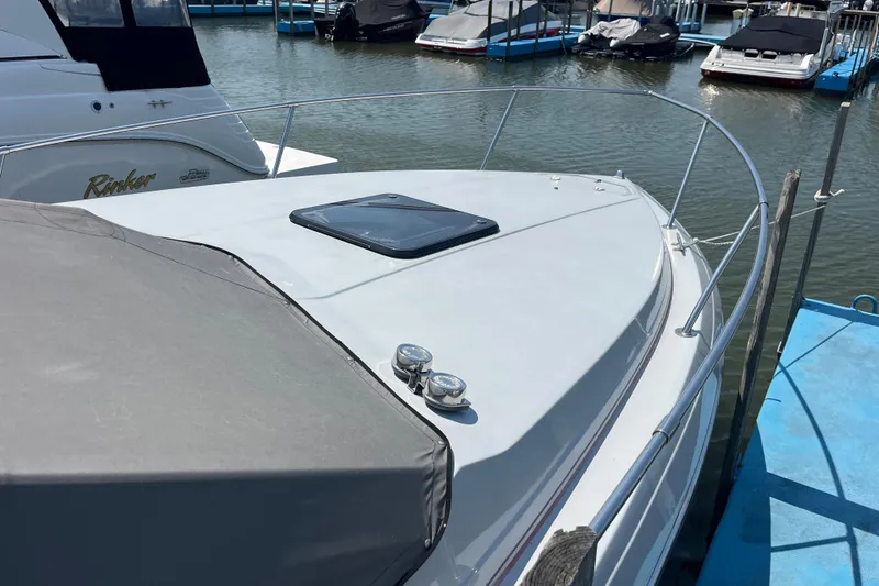 Slide: The Image of 1988 Four Winns 235 Sundowner boat docked at marina, featuring sleek design and spacious deck. - 23