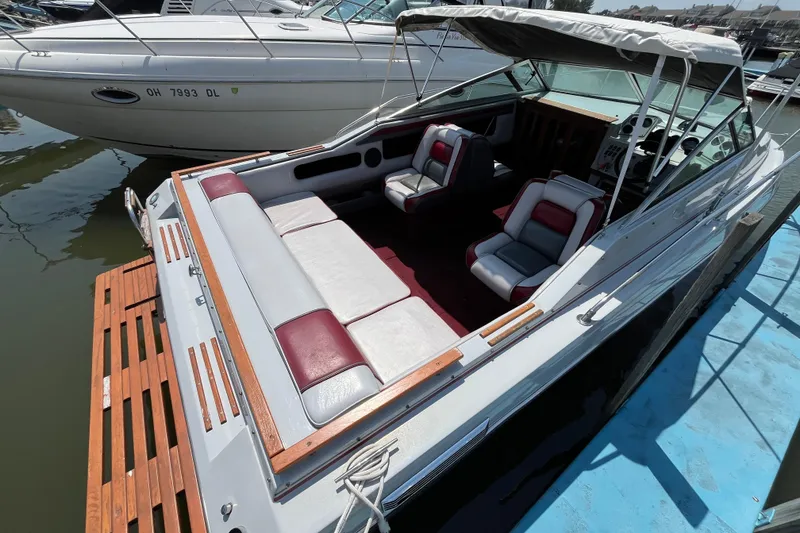Slide: The Image of 1988 Four Winns 235 Sundowner boat with spacious seating, docked at marina. - 3