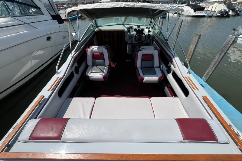Slide: The Image of 1988 Four Winns 235 Sundowner boat interior with red and white seating, docked at marina. - 4