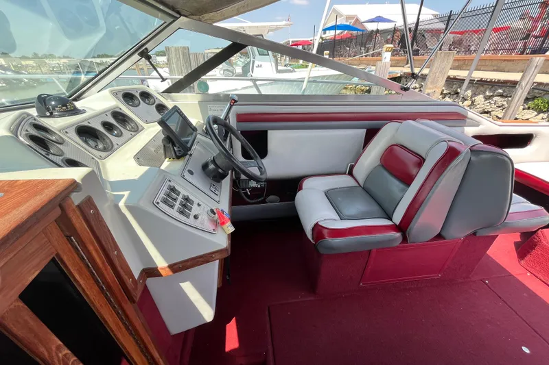 Slide: The Image of 1988 Four Winns 235 Sundowner boat interior with steering wheel and dashboard controls. - 7
