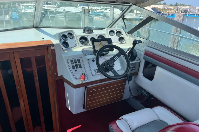 Slide: The Image of 1988 Four Winns 235 Sundowner boat cockpit with steering wheel and control panel. - 8