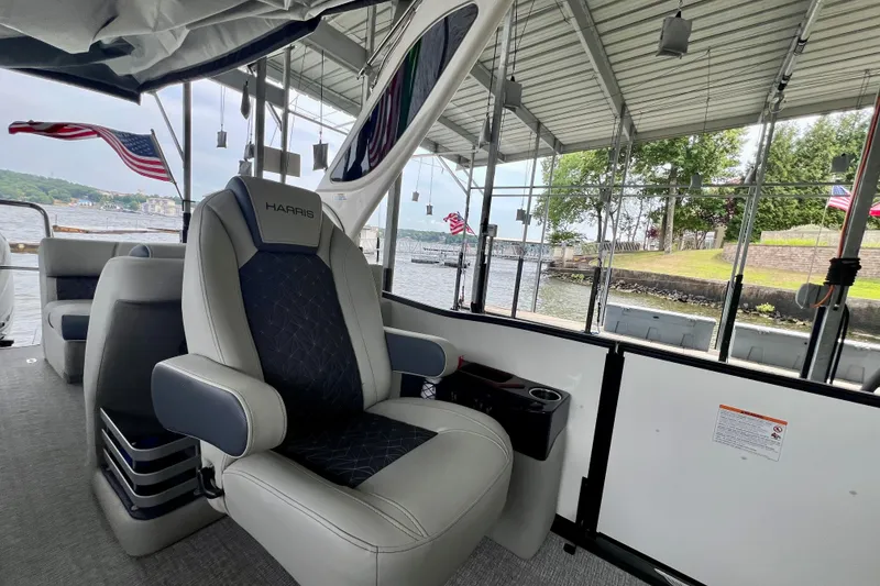 Slide: The Image of 2025 Harris Grand Mariner 250 boat interior with luxurious seating and scenic waterfront view. - 14