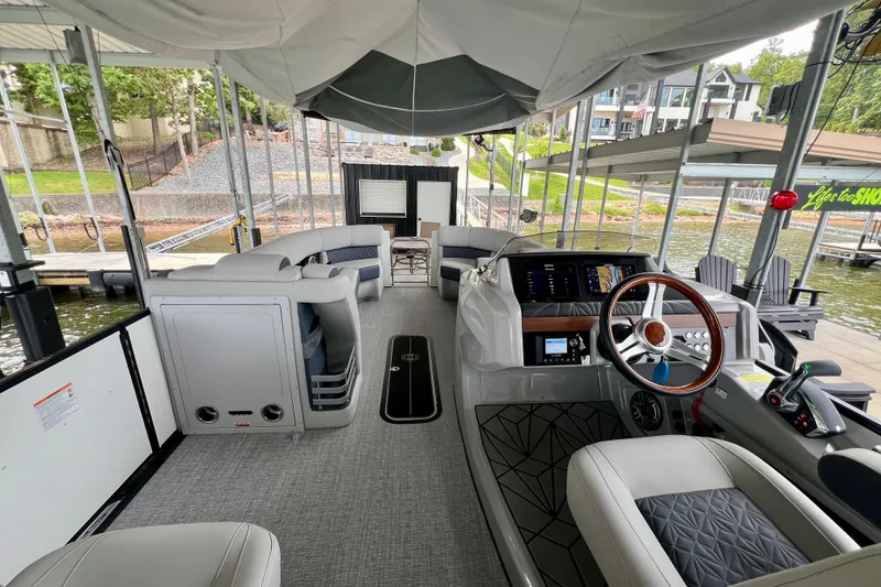 Slide: The Image of 2025 Harris Grand Mariner 250 pontoon boat interior with modern helm and spacious seating. - 15