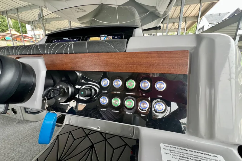 Slide: The Image of 2025 Harris Grand Mariner 250 dashboard with control panel and ignition keys. - 18