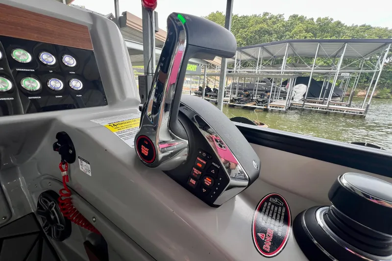 Slide: The Image of Control panel of 2025 Harris Grand Mariner 250 boat with throttle and buttons, dock view. - 22