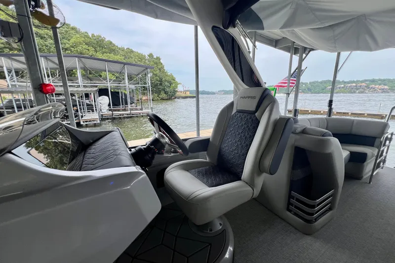 Slide: The Image of 2025 Harris Grand Mariner 250 interior with luxurious seating and scenic lake view. - 23