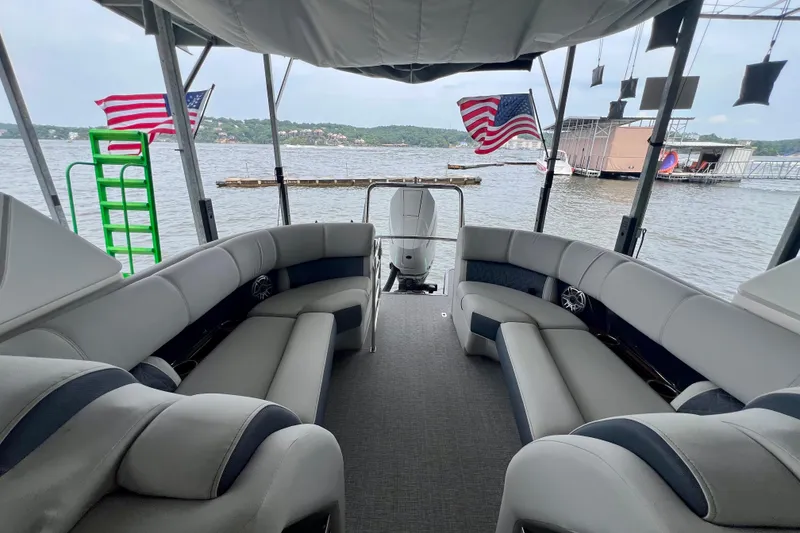 Slide: The Image of 2025 Harris Grand Mariner 250 pontoon boat interior with lake view and American flags. - 25