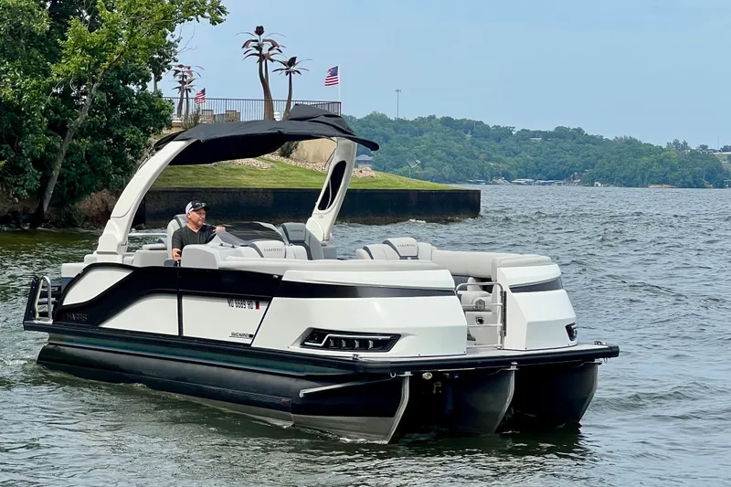 Slide: The Image of 2025 Harris Grand Mariner 250 pontoon boat cruising on a scenic lake. - 3