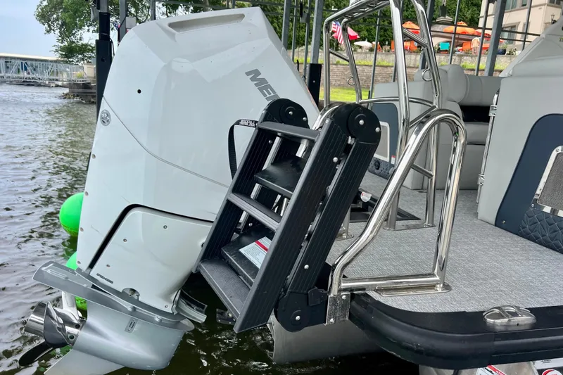 Slide: The Image of 2025 Harris Grand Mariner 250 boat with outboard motor and boarding ladder on a lake. - 5