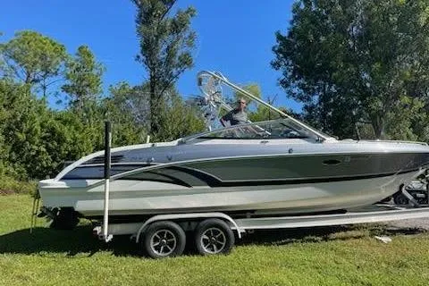Slide: The Image of 2017 Formula 270 Bowrider boat on trailer, parked on grass with trees in background. - 35