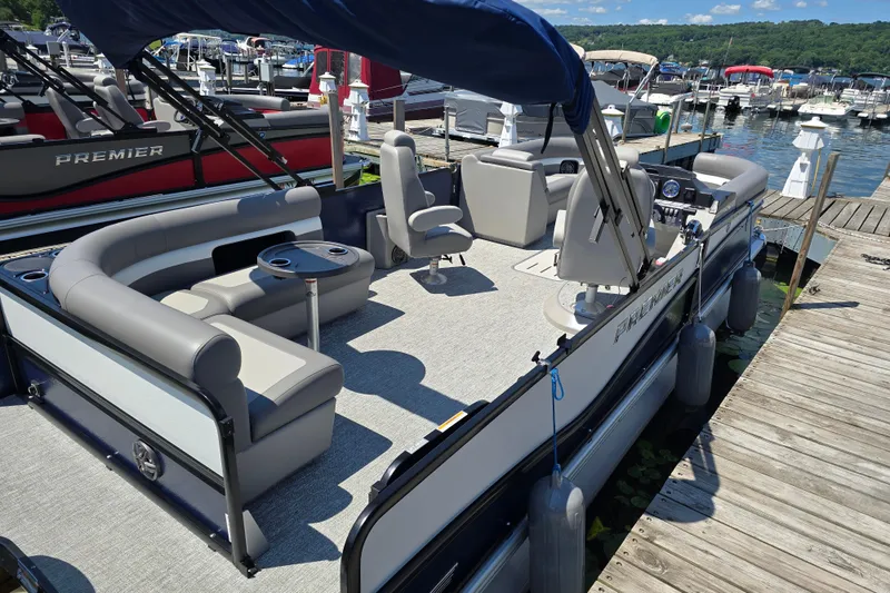 Slide: The Image of 2025 Premier 230 Sunsation RE pontoon boat docked, featuring spacious seating and modern design. - 13