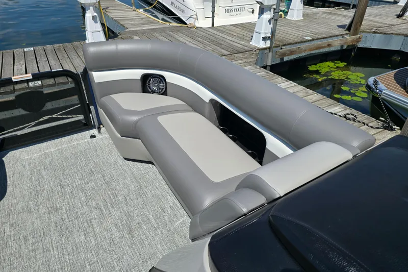 Slide: The Image of 2025 Premier 230 Sunsation RE pontoon boat with gray seating at a dock. - 16