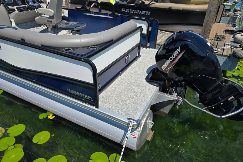 Slide: The Image of 2025 Premier 230 Sunsation RE pontoon boat with Mercury outboard motor on a lake. - 7