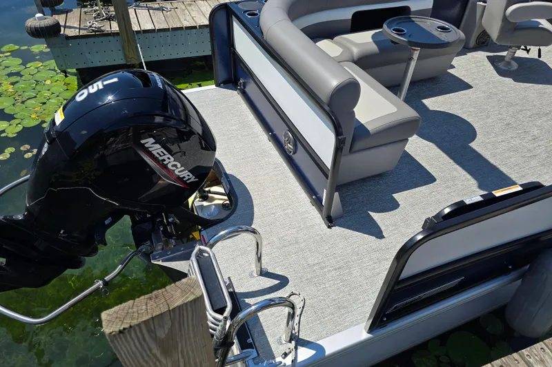 Slide: The Image of 2025 Premier 230 Sunsation RE pontoon boat with Mercury outboard motor, docked by lily pads. - 9