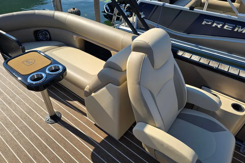 Slide: The Image of Luxurious seating on 2025 Premier 230 SunSation RF pontoon boat with cup holders and table. - 11