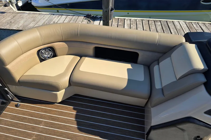 Slide: The Image of Luxurious seating on 2025 Premier 230 SunSation RF boat, featuring beige upholstery and integrated speaker. - 12