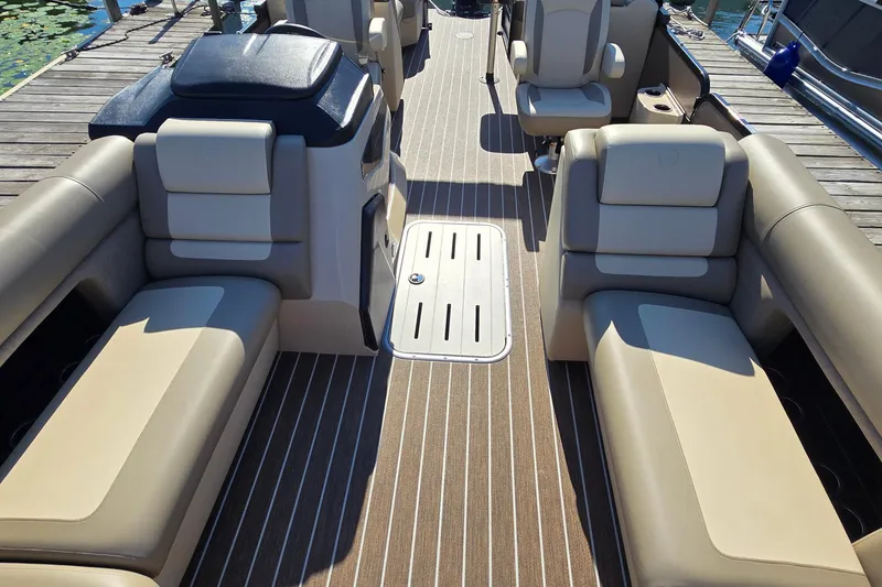 Slide: The Image of 2025 Premier 230 SunSation RF pontoon boat interior with beige seating and wood-style flooring. - 13