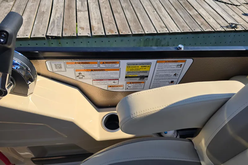 Slide: The Image of 2025 Premier 230 SunSation RF boat dashboard with warning labels and controls. - 9