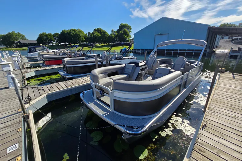 The Image of 2025 Premier 230 SunSation RF pontoon boat docked at a marina under clear skies. - 1
